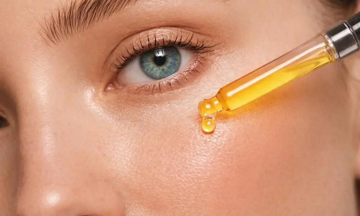 Kropla serum z pipety na skórze. Uważaj na retinol efekty uboczne, jak zaczerwienienie czy suchość.