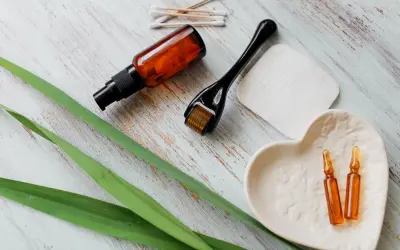 Zestaw do pielęgnacji: serum z **retinolem**, roller, ampułki i waciki.