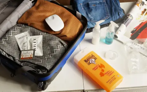 Pakowanie kosmetyków do bagażu podręcznego: małe buteleczki, próbki i żel pod prysznic Le Petit Marseillais.